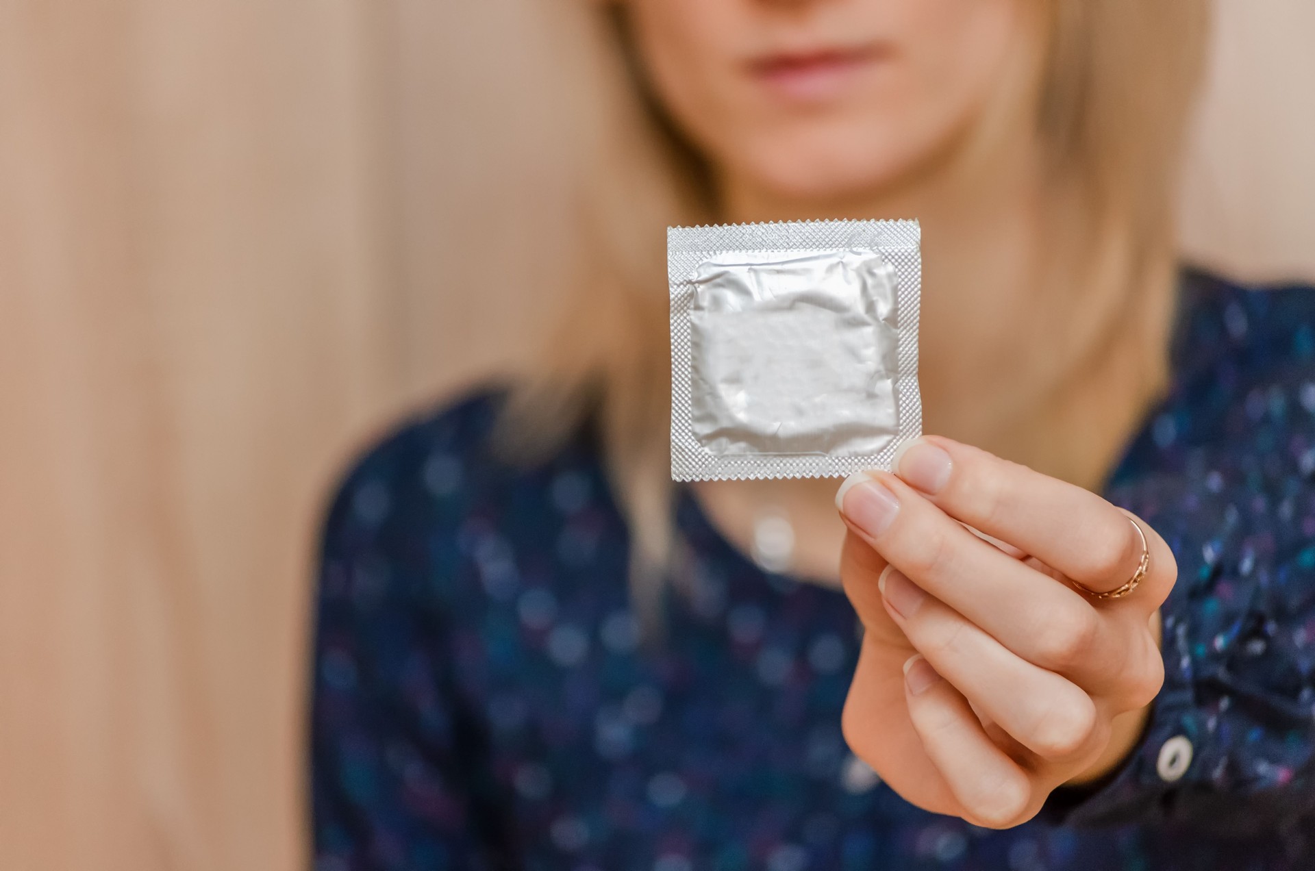 Condom ready to use in female hand, give condom safe sex concept. Prevent infection and Contraceptives control the birth rate or safe prophylactic.