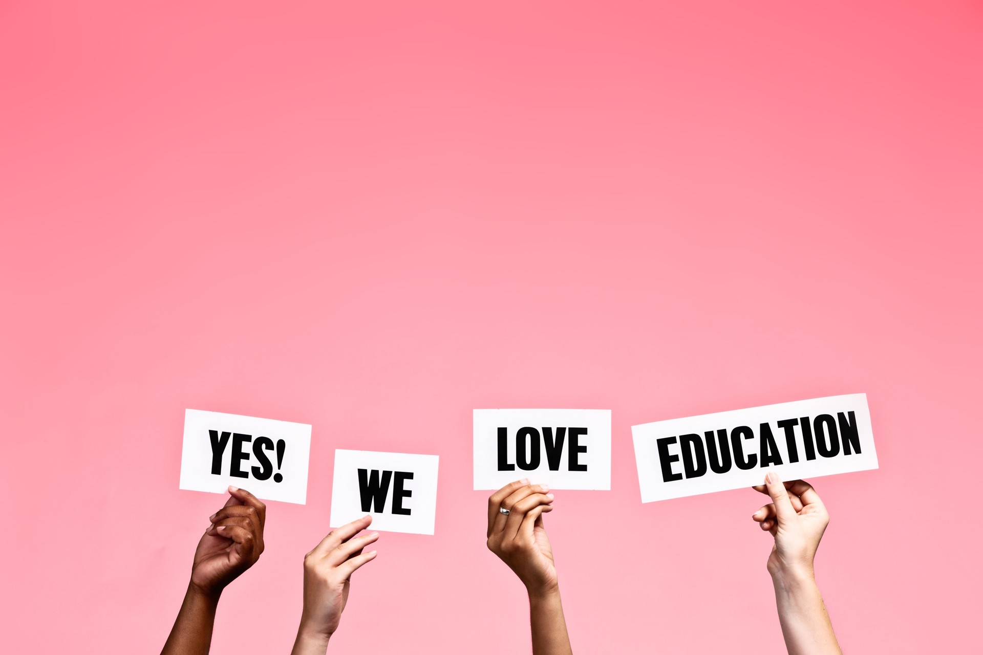 Hand-held signs say "Yes! We love education"