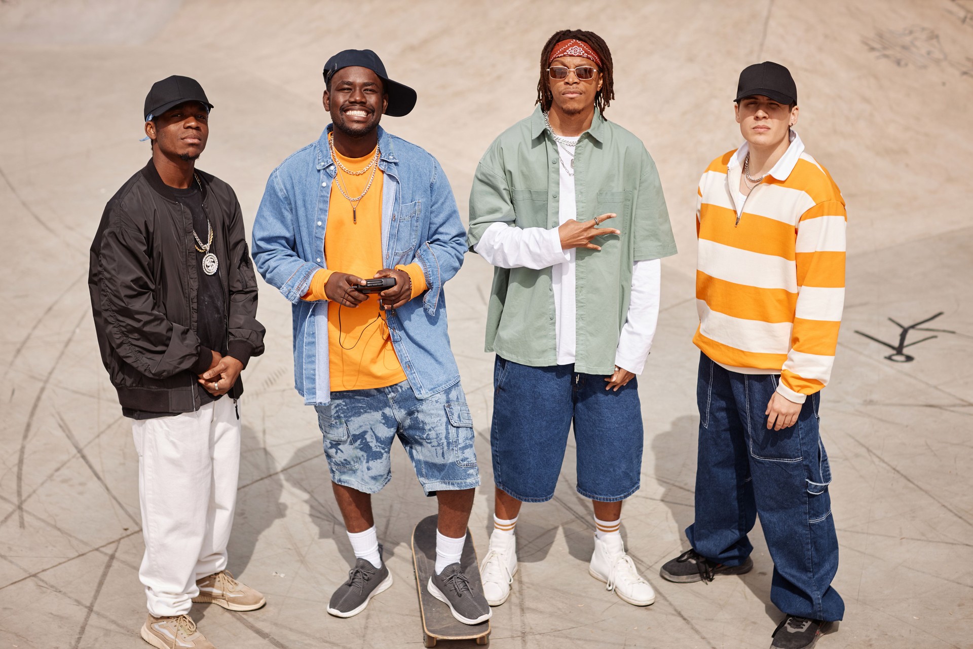 Group of four young intercultural members of boy band looking at camera