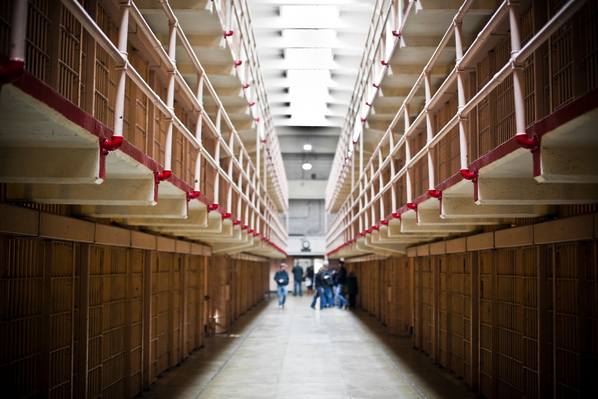 Middle ground floor hallway of a prison with blurred inmates